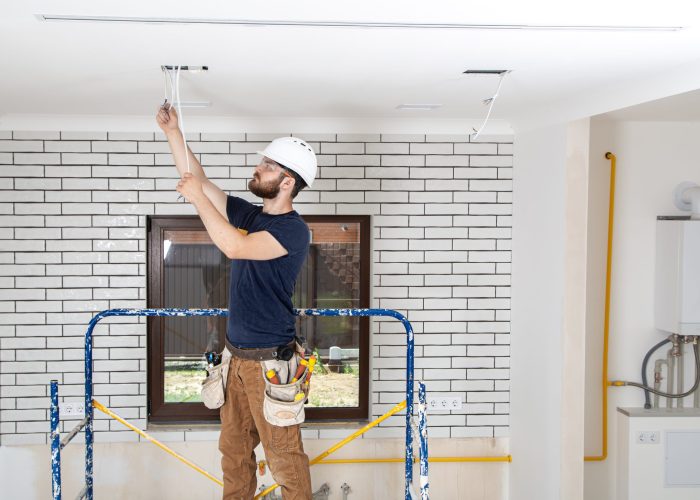 Professional in overalls with tools on the background of the repair site. Home renovation concept.